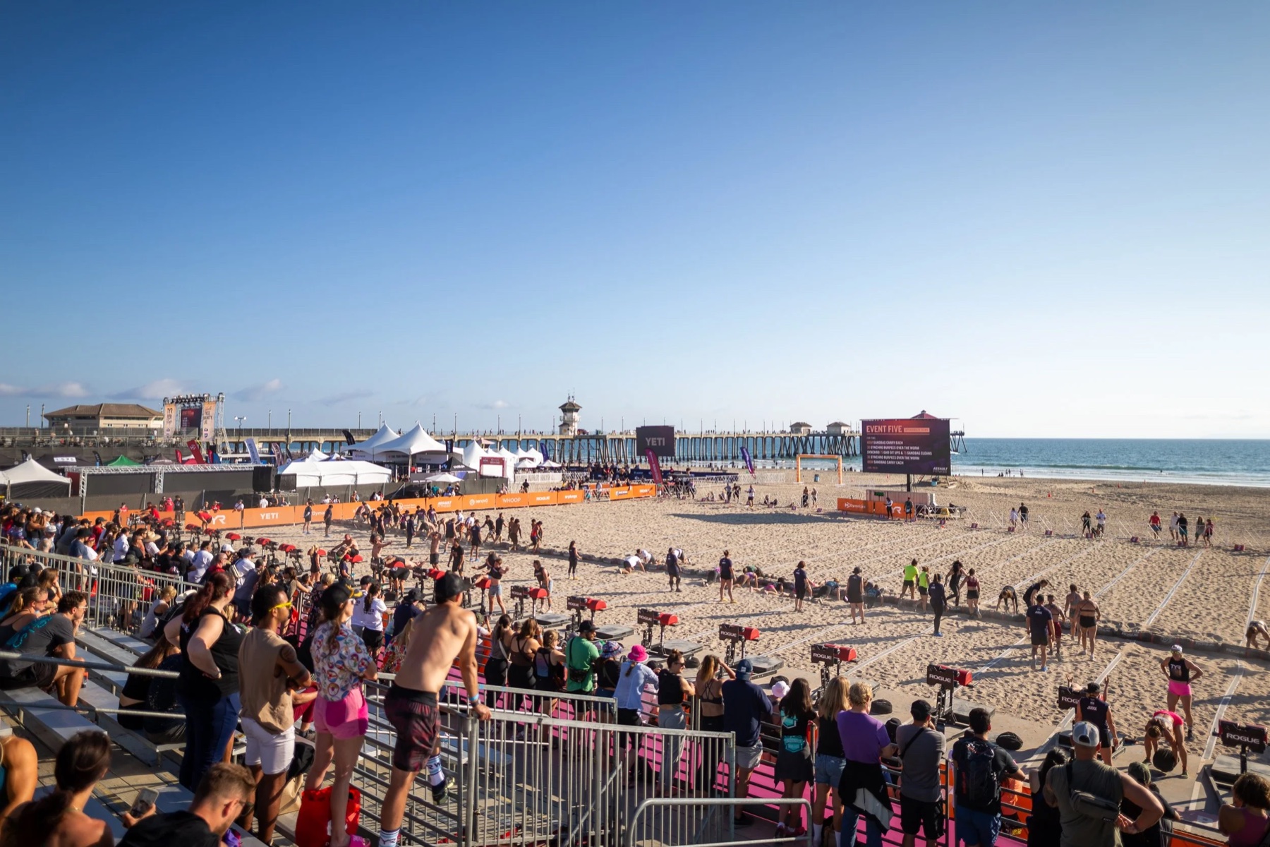 Competitors and fans on the sand at Huntington Beach Pier